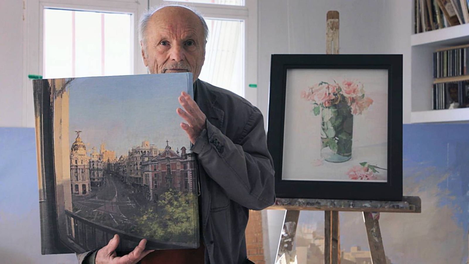 Antonio López con el libro "Paisajes" y la lámina de su obra "Rosas" de fondo.