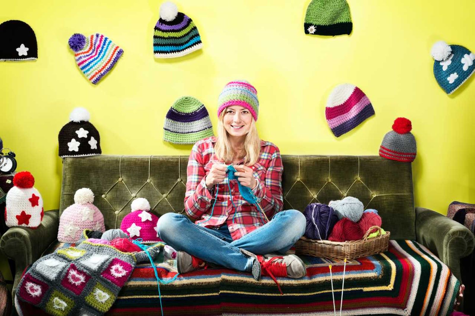 Mujer tejiendo gorros de invierno.