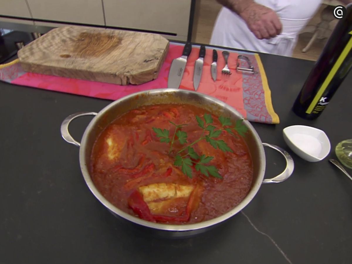 Ración de bacalao a la riojana lista para servir, con su salsa de tomate y pimientos.