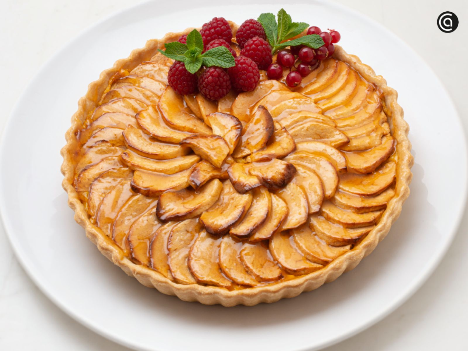 El brillo dorado de una tarta de manzana recién horneada, con ese aroma inconfundible a mantequilla y canela que llena la cocina.