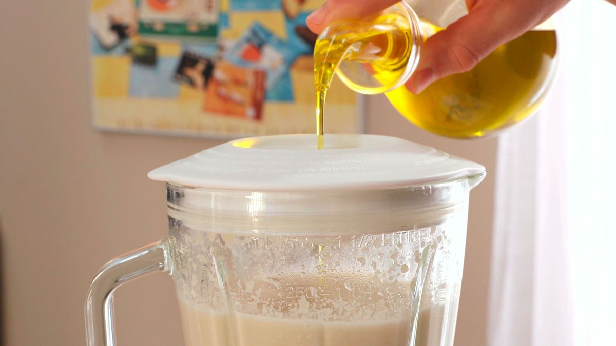 Incorpora el aceite de oliva lentamente mientras sigues triturando la mezcla para conseguir una textura cremosa y suave