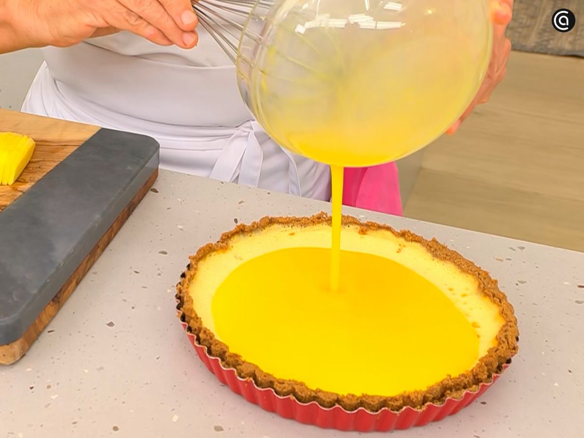Vierte la mezcla de gelatina de mango sobre la superficie de la tarta
