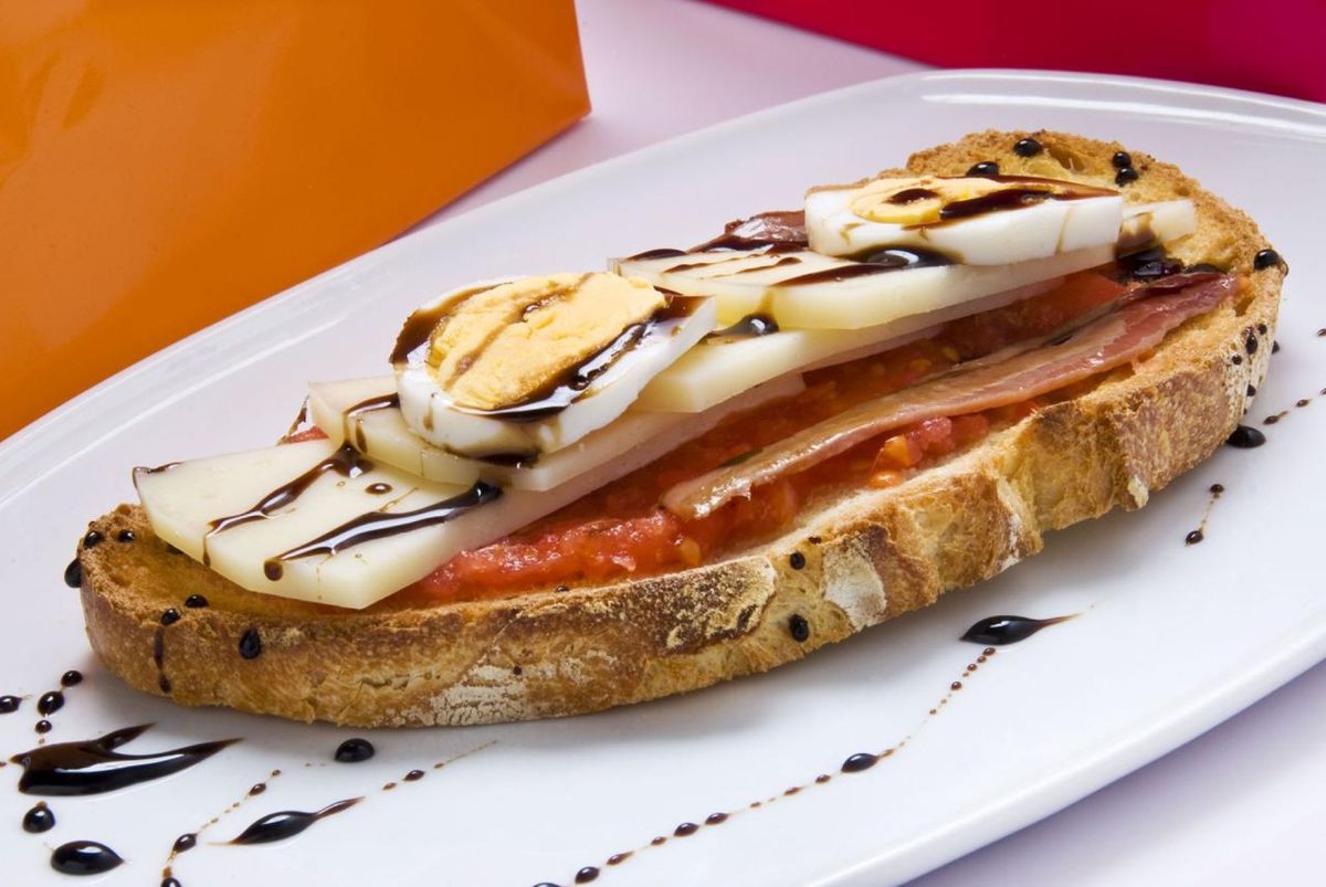 Tosta de anchoa, tomate, queso manchego y huevo duro