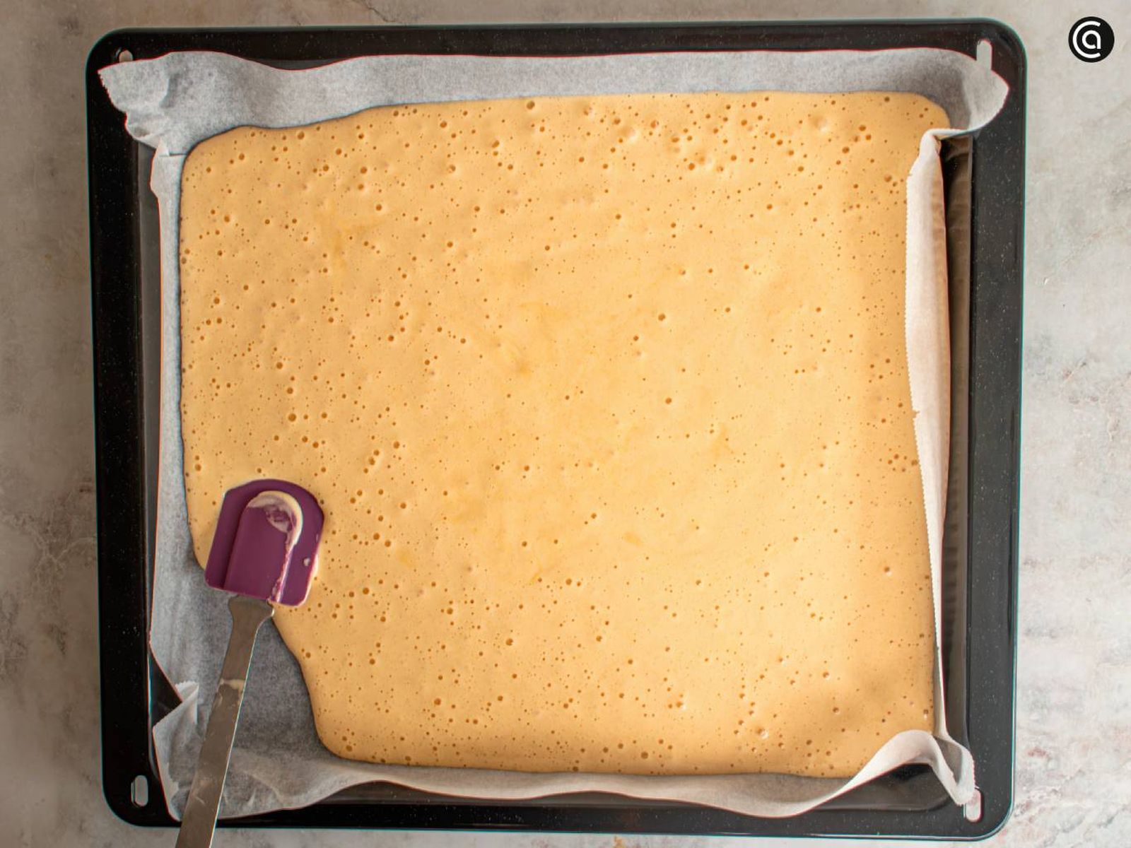 Vierte la masa en una bandeja de horno forrada con papel vegetal