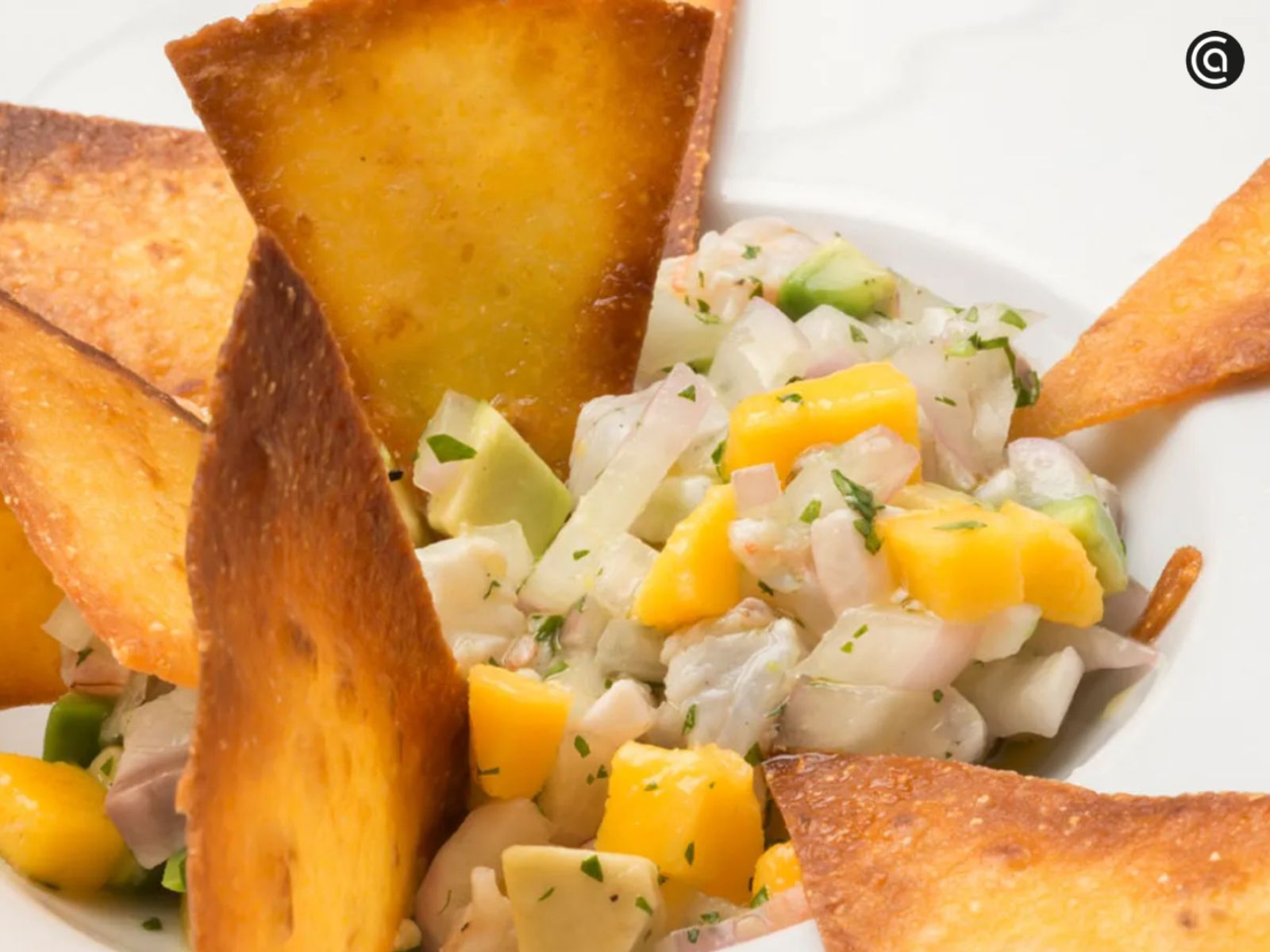 Un plato fresco y colorido que combina sabores cítricos, dulces y marinos, acompañado de crujientes totopos. Un plato fresco y colorido que combina sabores cítricos, dulces y marinos, acompañado de crujientes totopos.