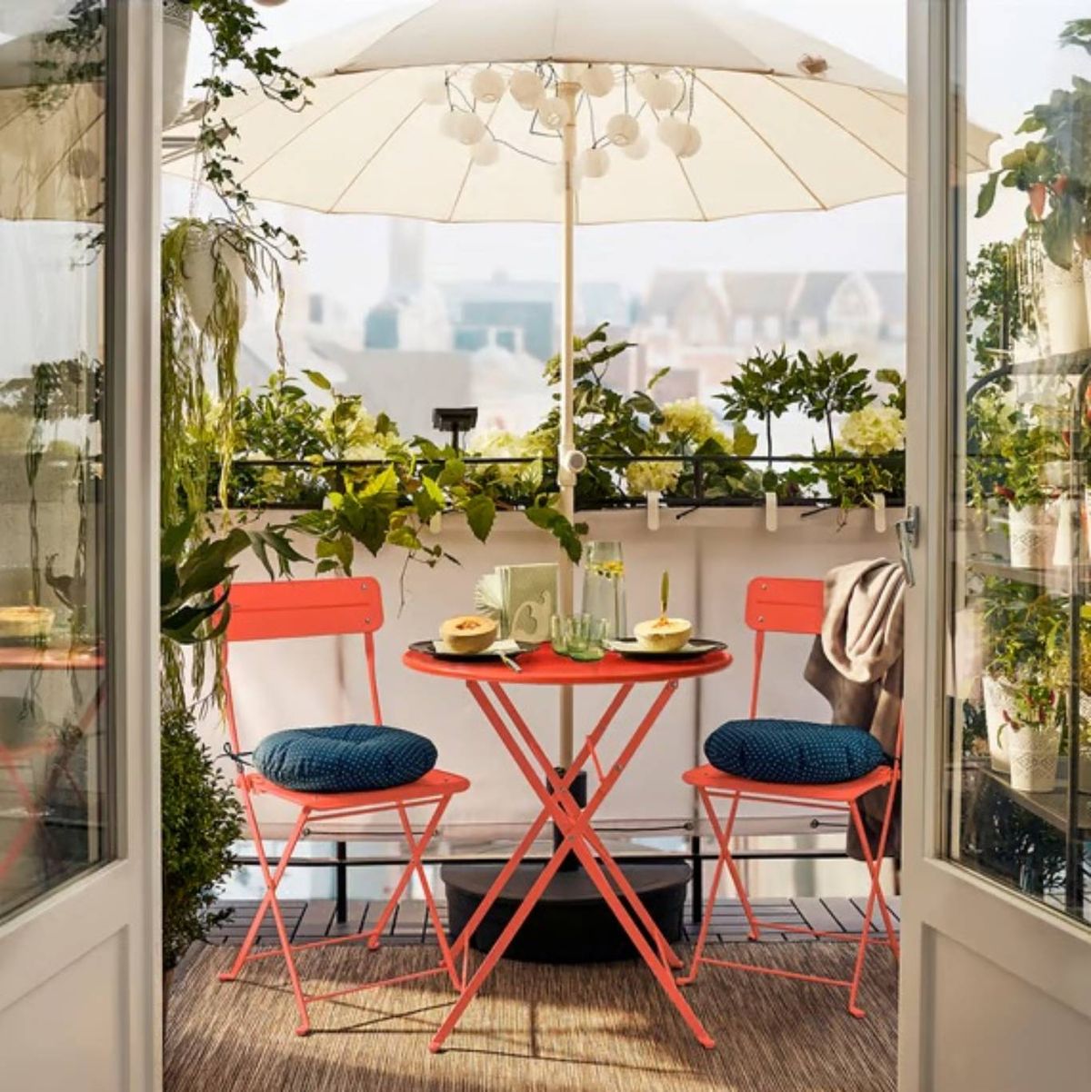 Terraza pequeña con muebles de metal rojos.