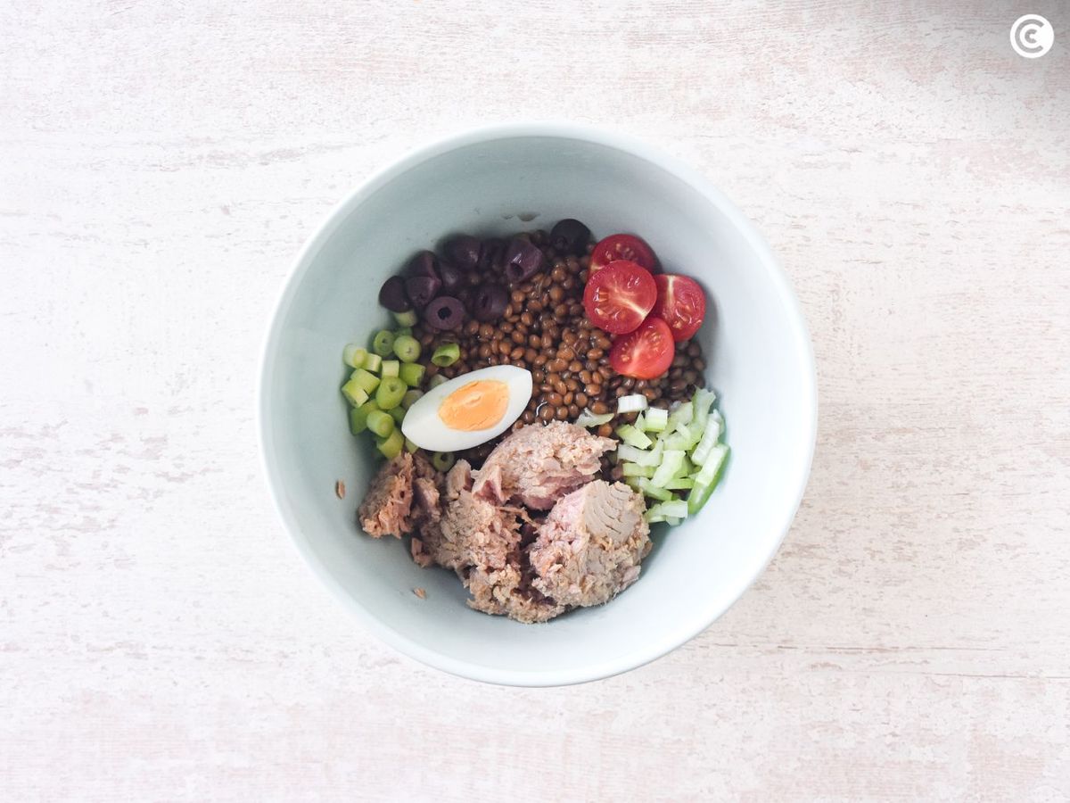 Mezclar los ingredientes para la ensalada de lentejas y atún