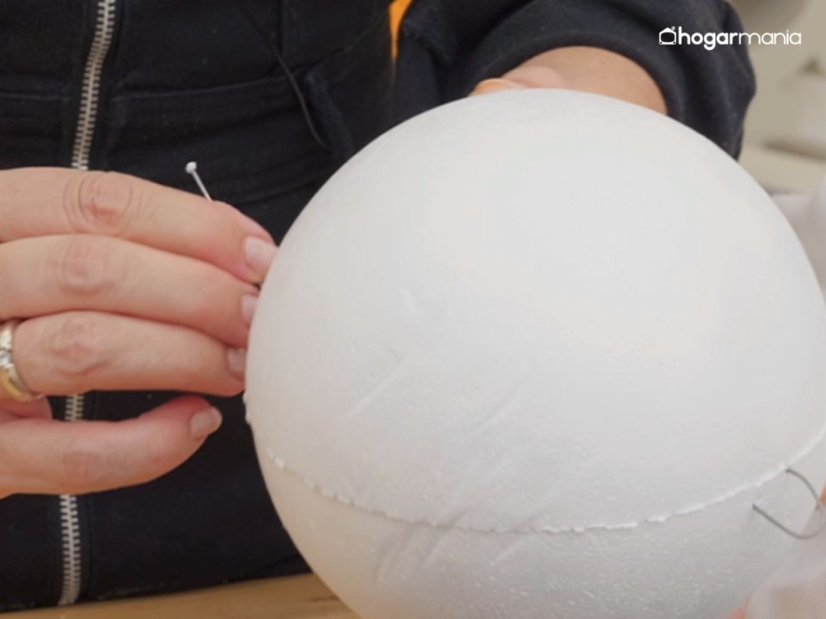 Clavamos un trozo de alambre en la bola de corcho para crear la estructura de la cabeza del fantasma.