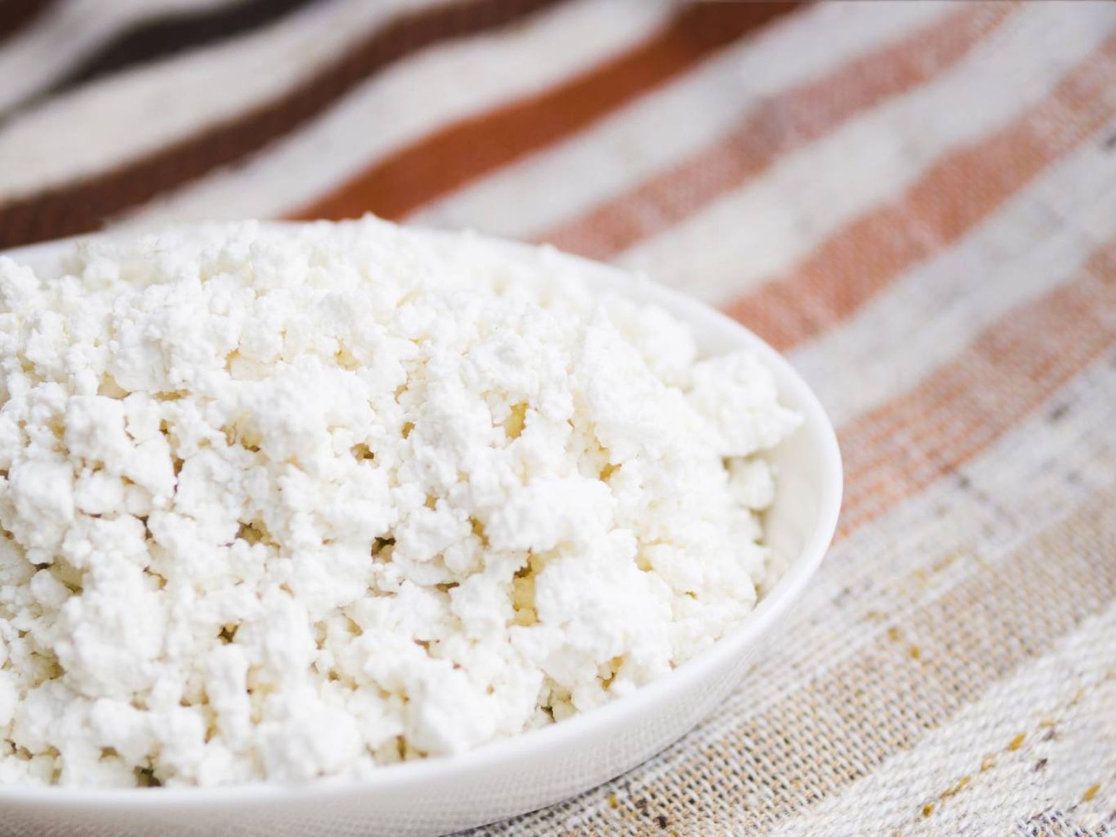 Queso cottage natural servido en un bol: bajo en grasa y rico en proteínas, ideal para cualquier momento del día.