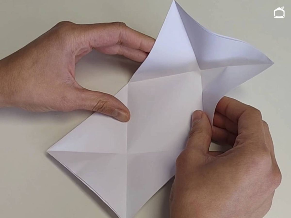 Dobla los extremos en triángulo, marcando una X.