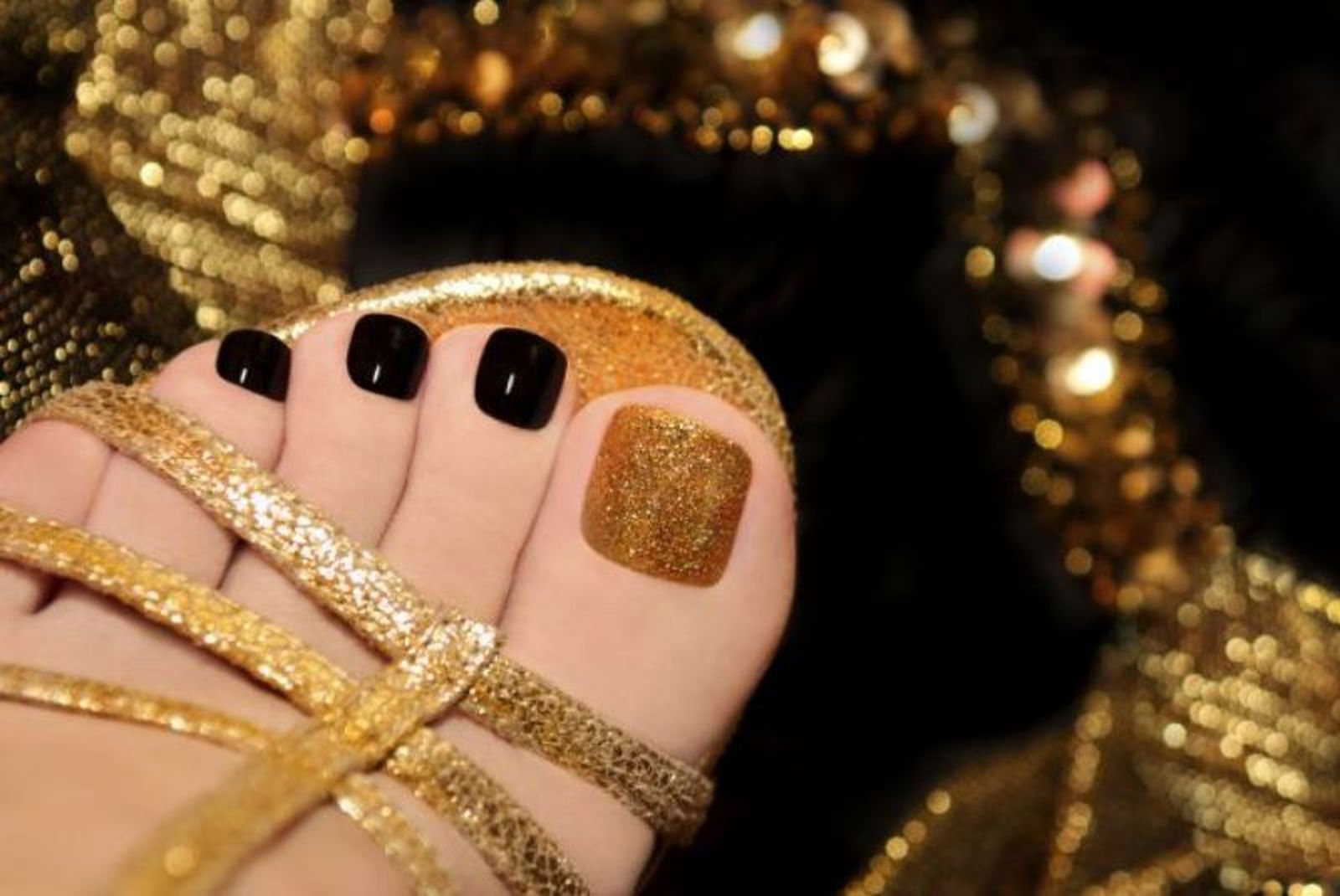 Pedicura en negro con detalle en dorado