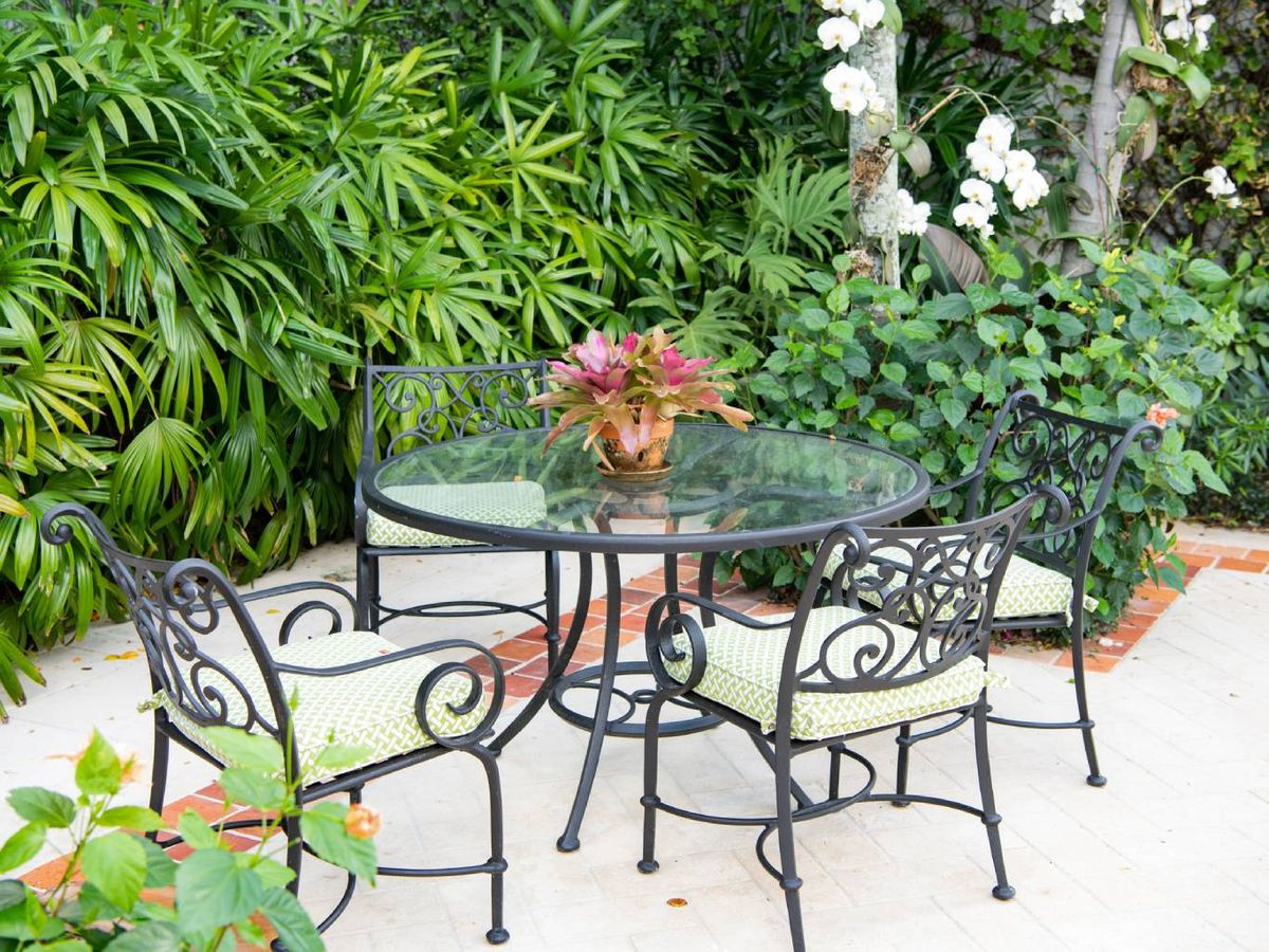 Jardín con muebles de exterior de metal.