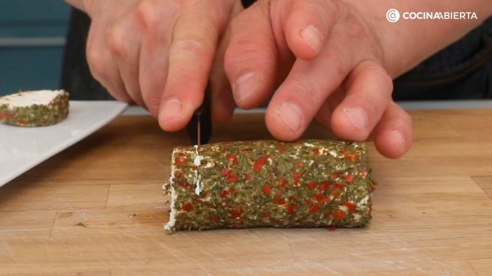 Corta el rulo de queso de cabra con finas hierbas Corta el rulo de queso de cabra con finas hierbas