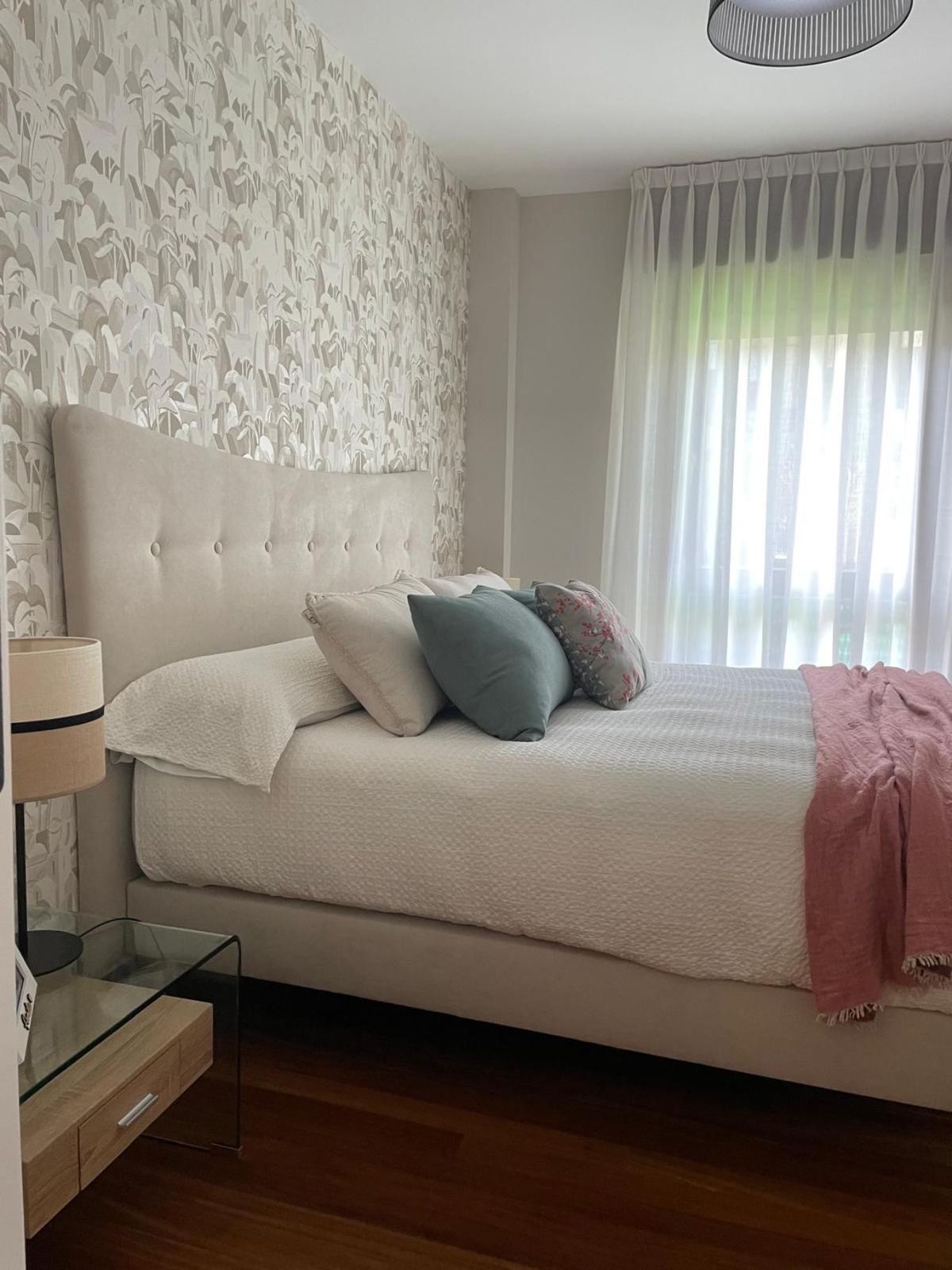 Dormitorio renovado con papel pintado y textiles actualizados.