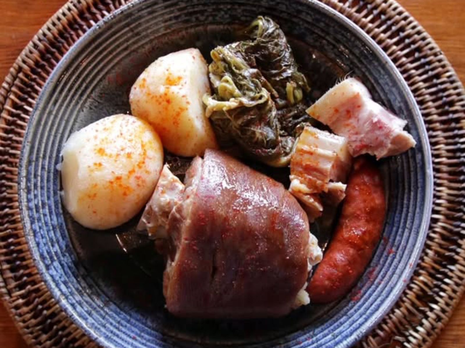 Un codillo cocido lentamente con patatas ourensanas, chorizo y grelos: pura tradición gallega en el plato.