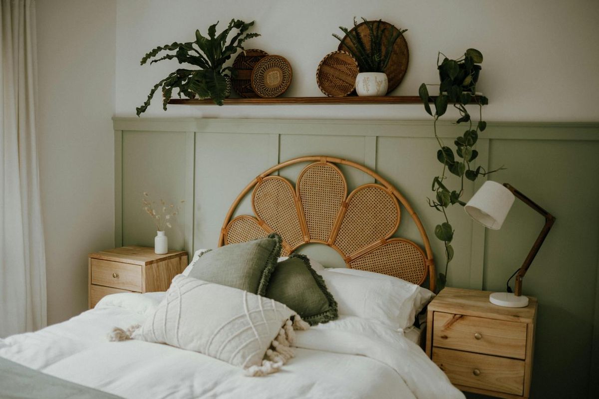 Dormitorio minimalista acogedor decorado en verde y con cabecero de fibras naturales.