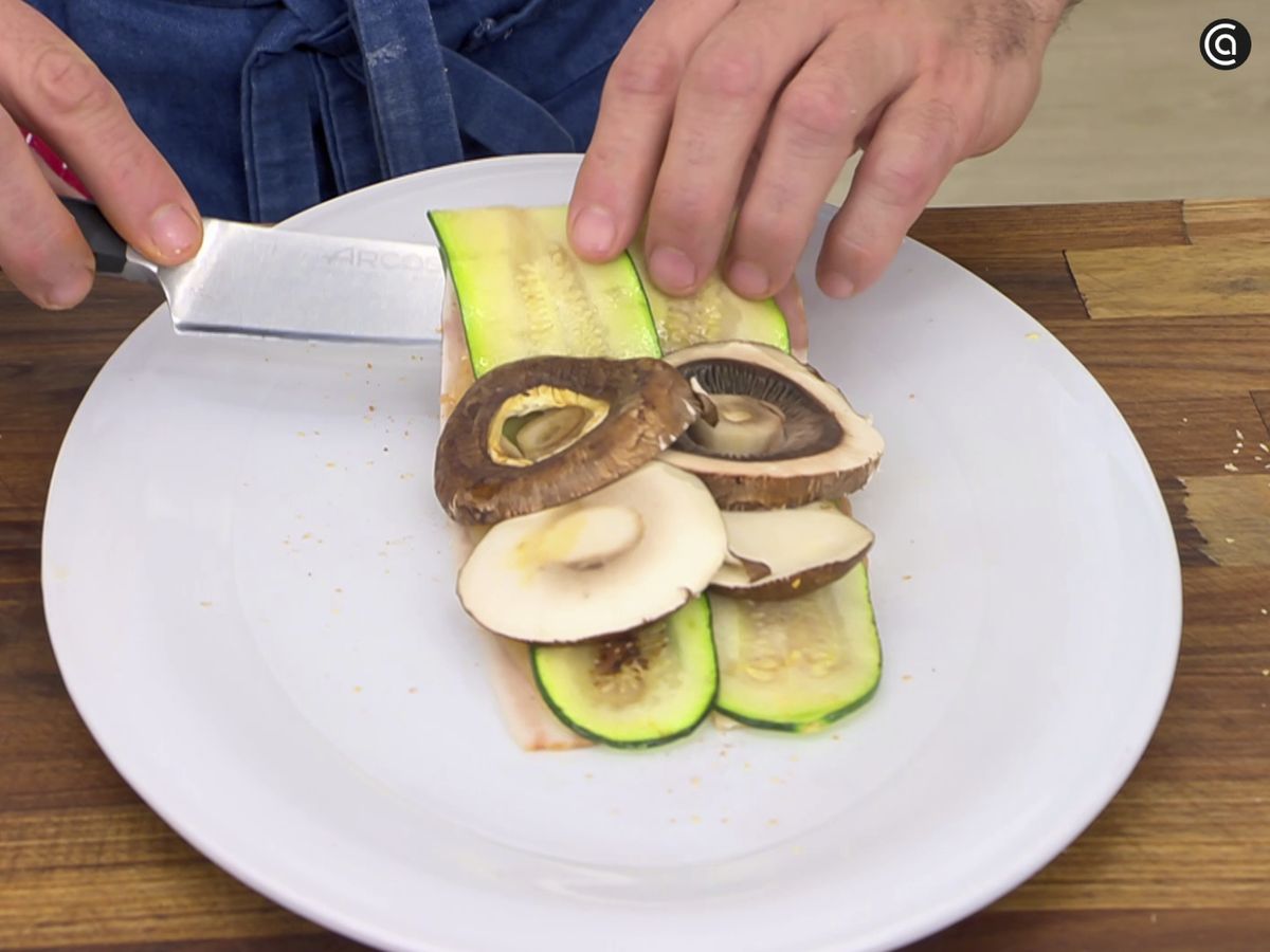 Enrolla dos lonchas de bacon con la pechuga, el calabacín y el champiñón