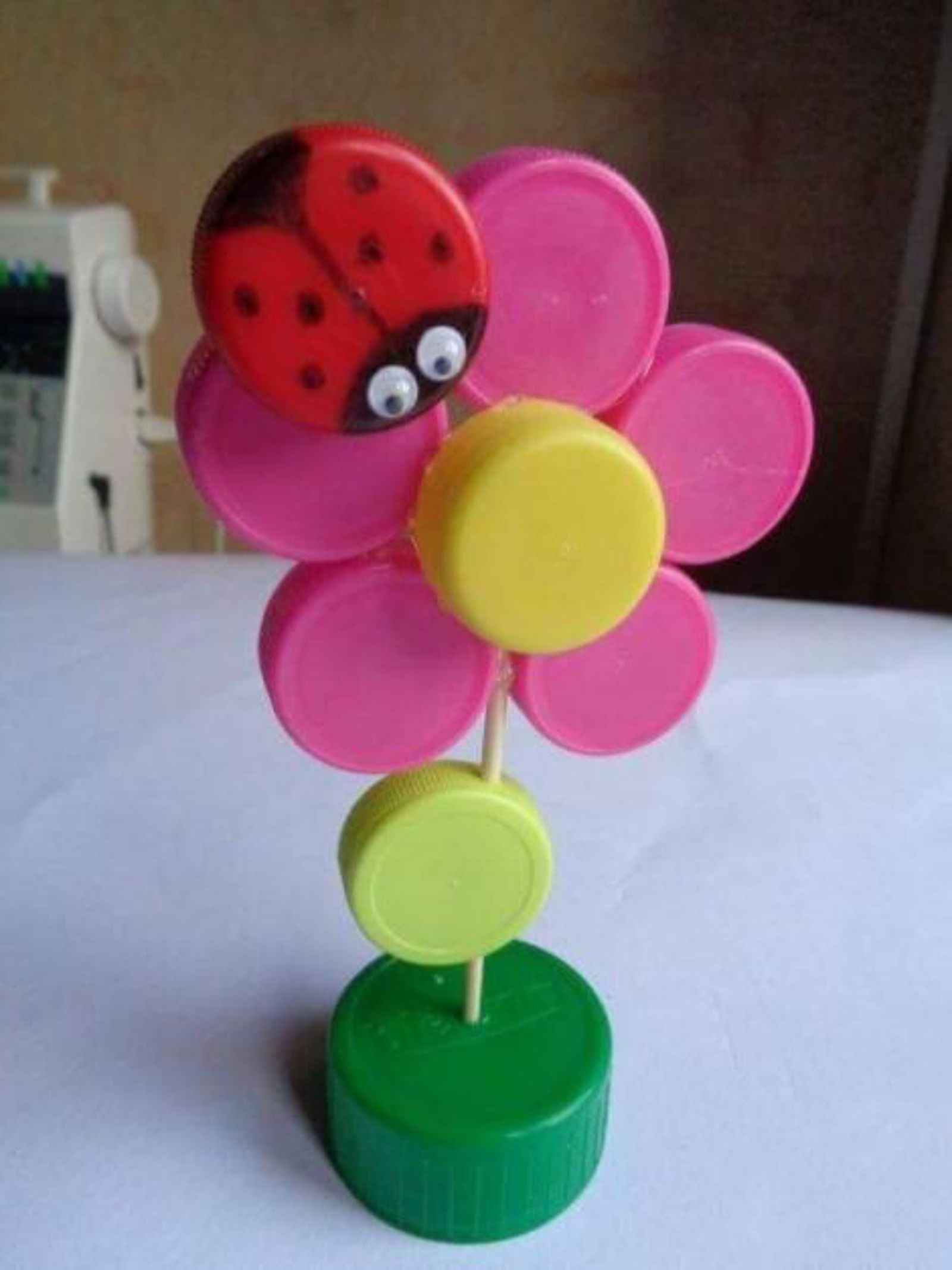 Adorno de flor con mariquita hecho con tapones de plástico. Adorno de flor con mariquita hecho con tapones de plástico.