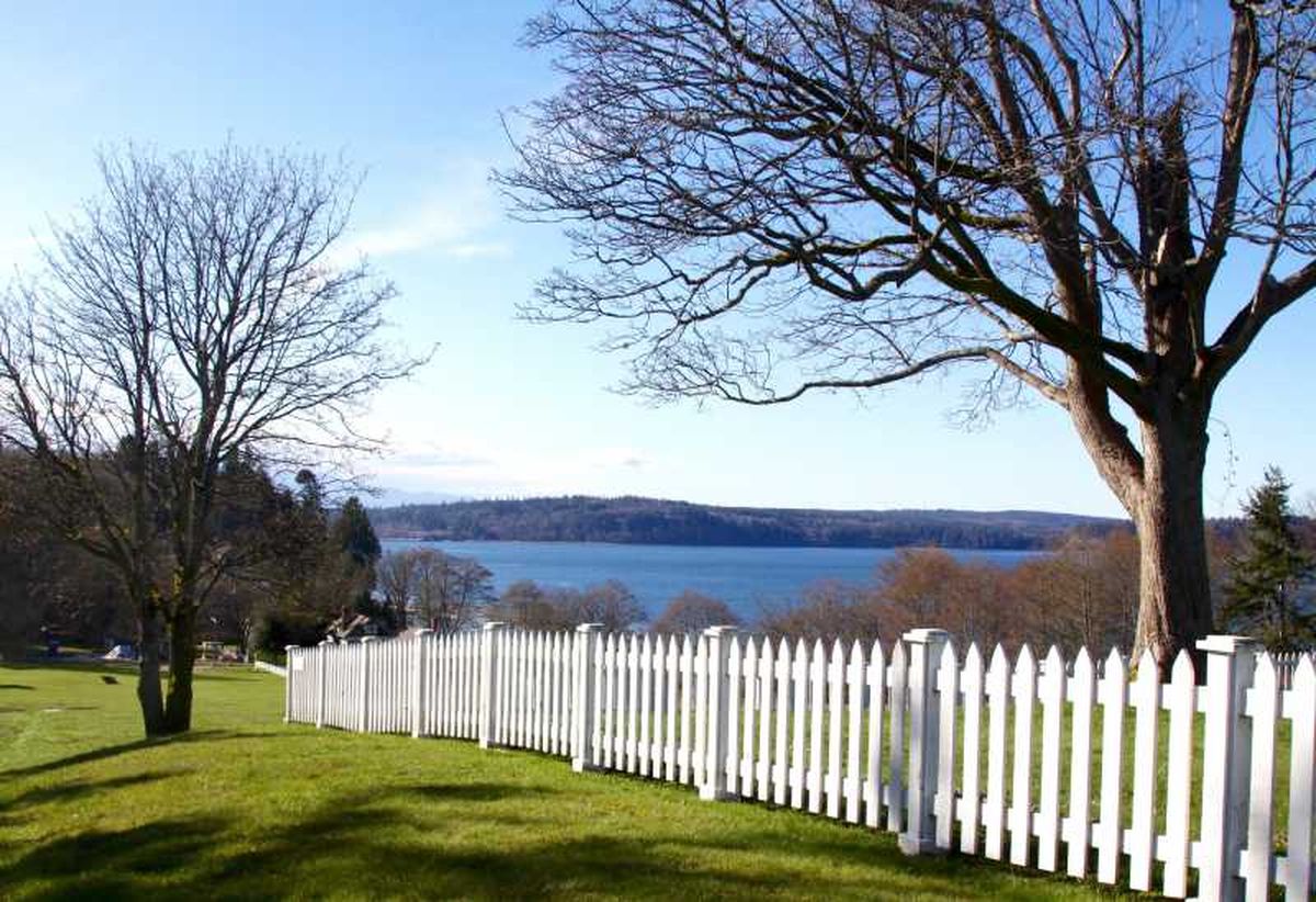 Jardín grande con valla pintada de blanco.