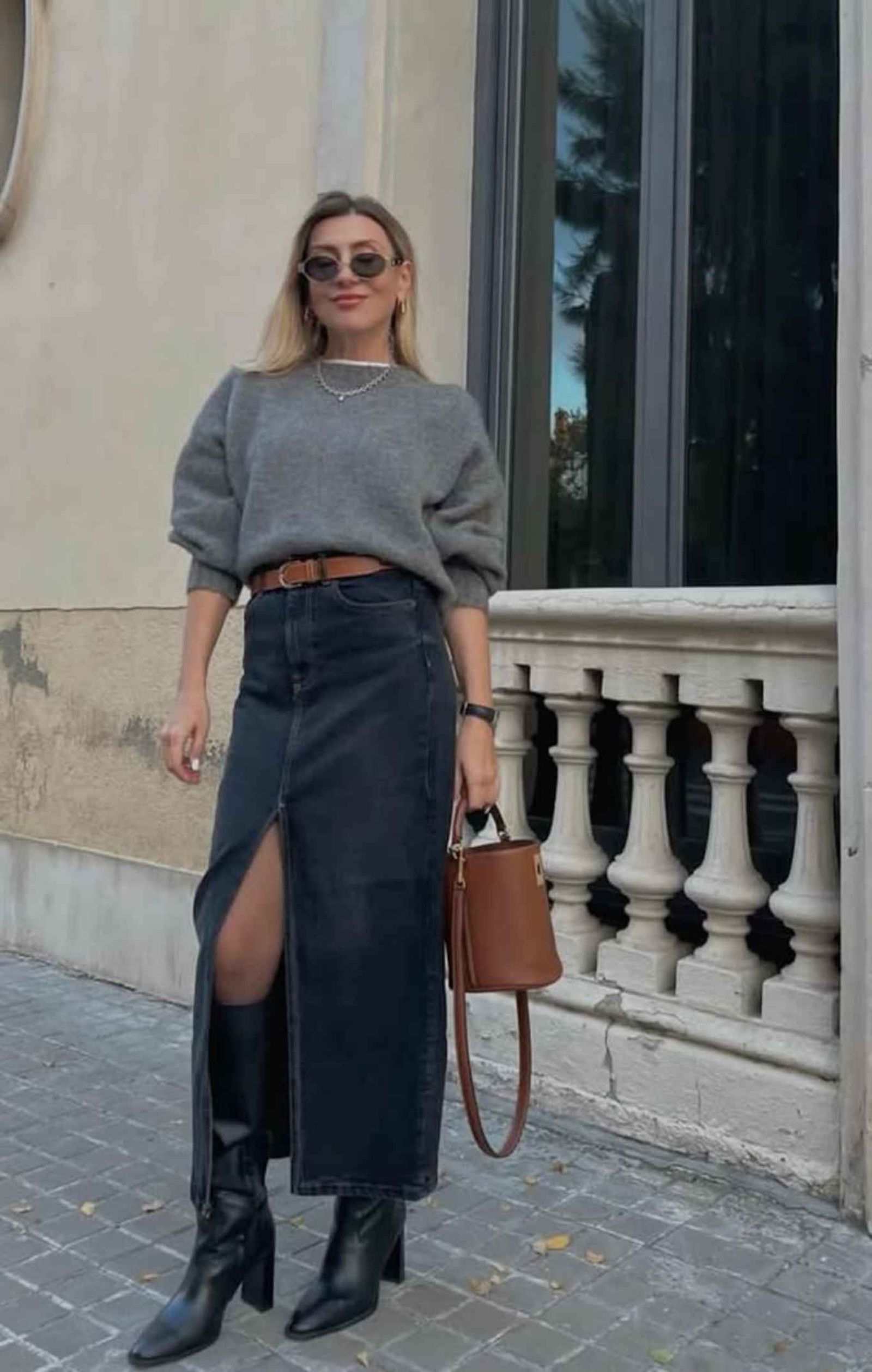 Falda vaquera oscura con suéter gris y botas altas. Falda vaquera oscura con suéter gris y botas altas.