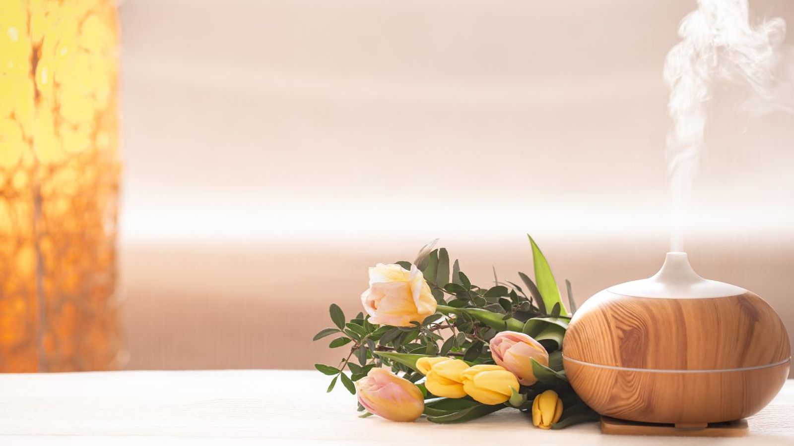 Humidificador con aromas al lado de unos tulipanes.