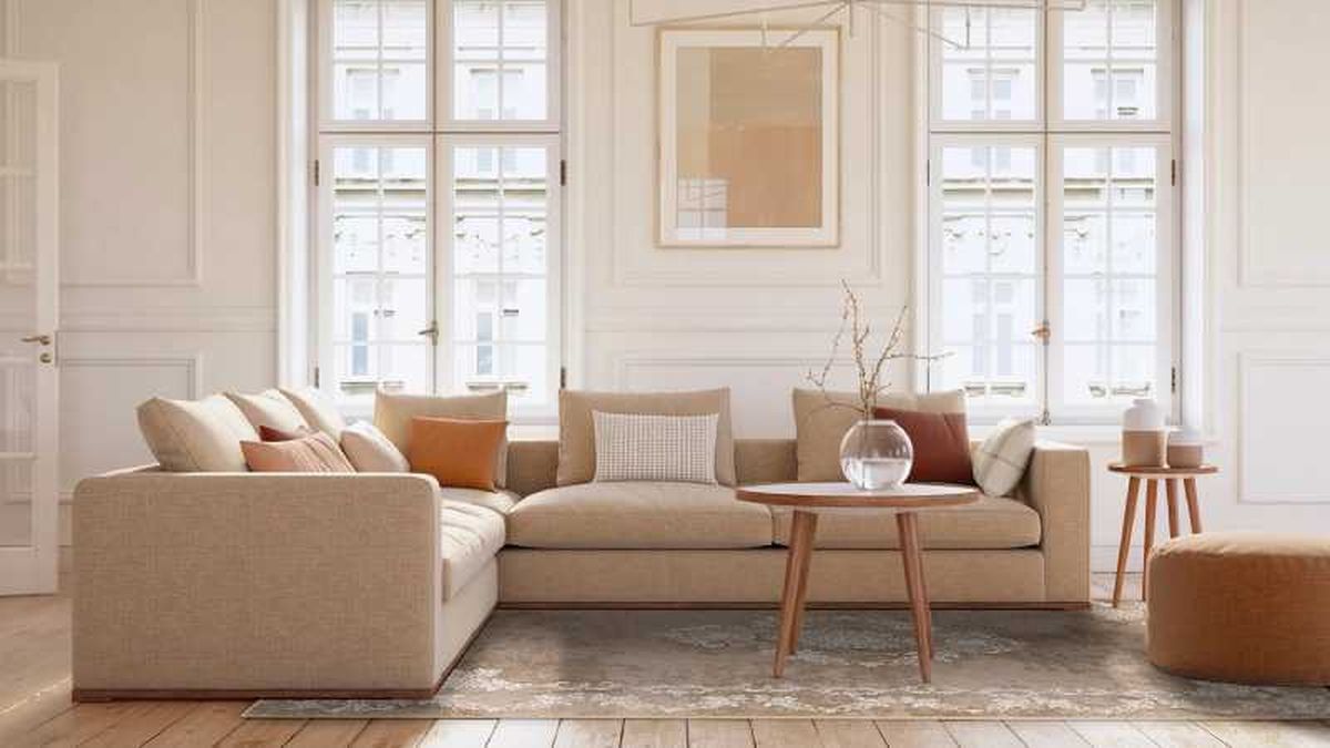 Salón elegante con sofá beige y cojines de colores.