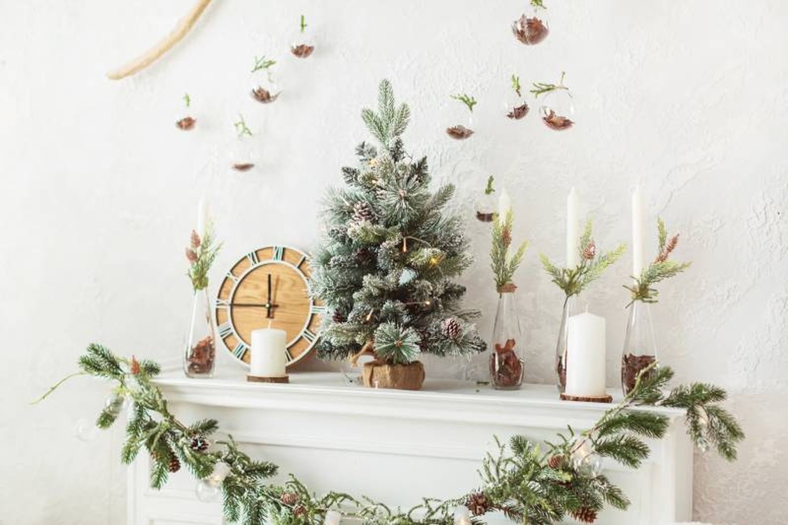 Chimenea con decoración de Navidad en blanco y con elementos naturales.