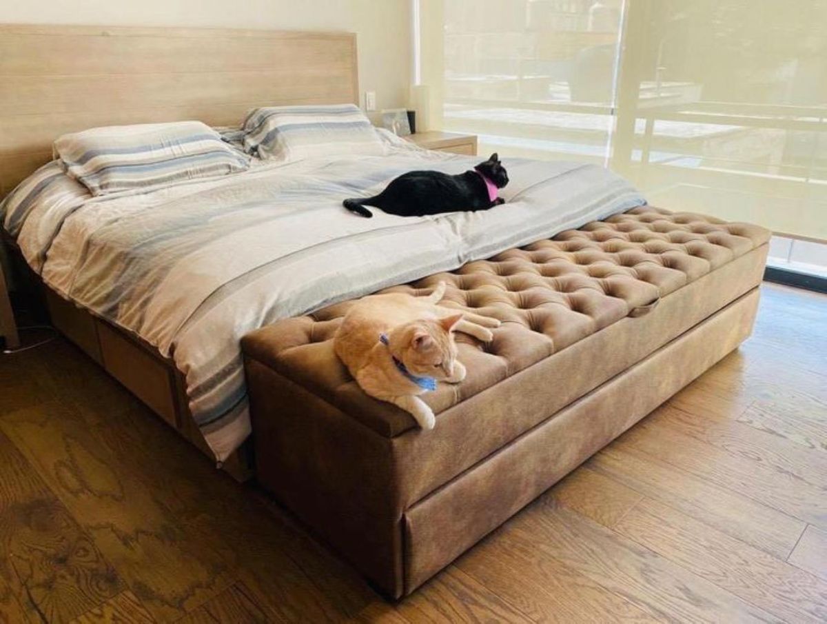 Dormitorio con puff de almacenamiento a los pies de la cama.