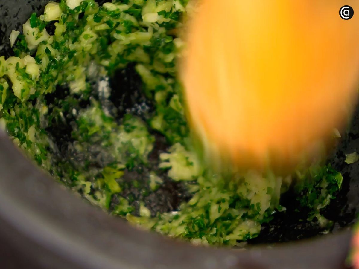 En un mortero, tritura el ajo y el perejil con aceite