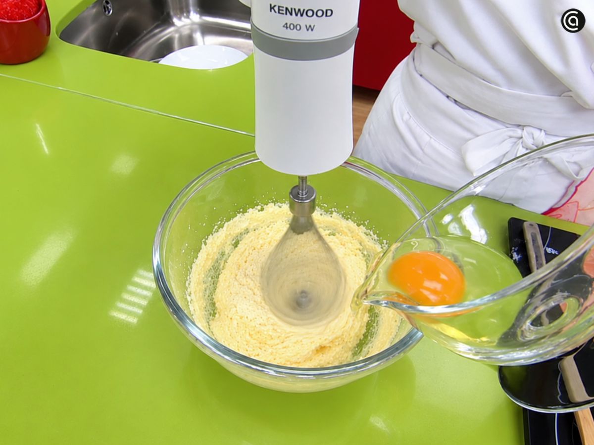 Añade los huevos a la mezcla de mantequilla y miel del bizcocho de nueces