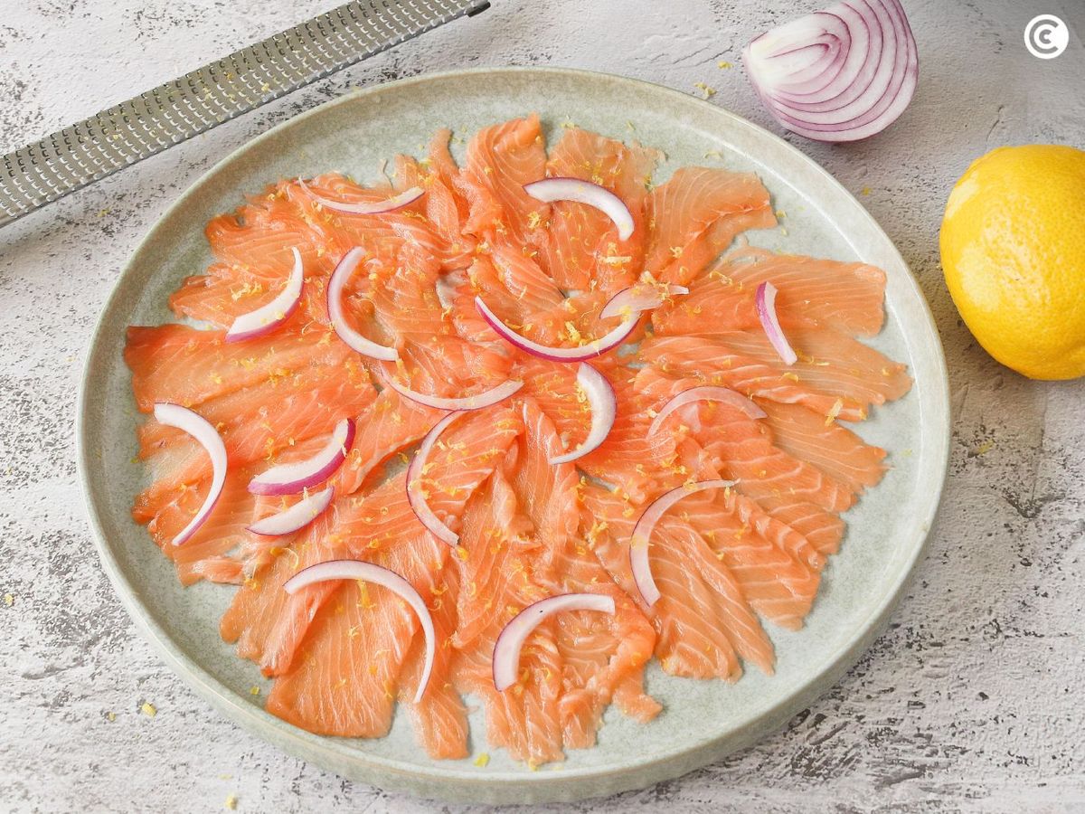 Carpaccio de salmón con ralladura de limón y cebolla morada