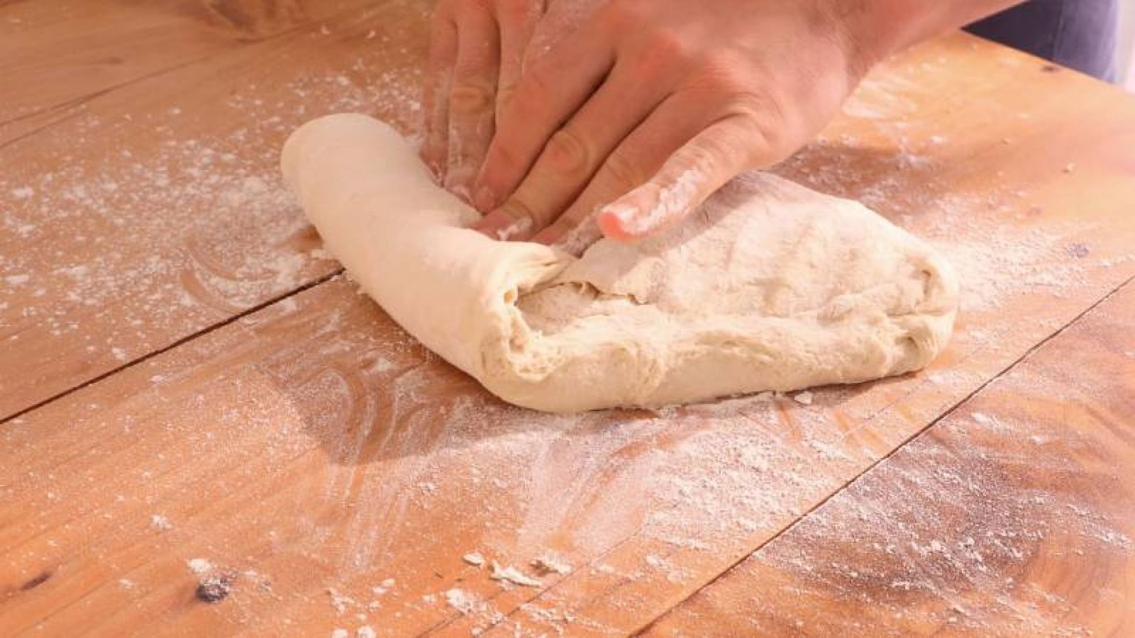 Dando forma a la masa de pan para crear una barra perfecta lista para hornear Dando forma a la masa de pan para crear una barra perfecta lista para hornear