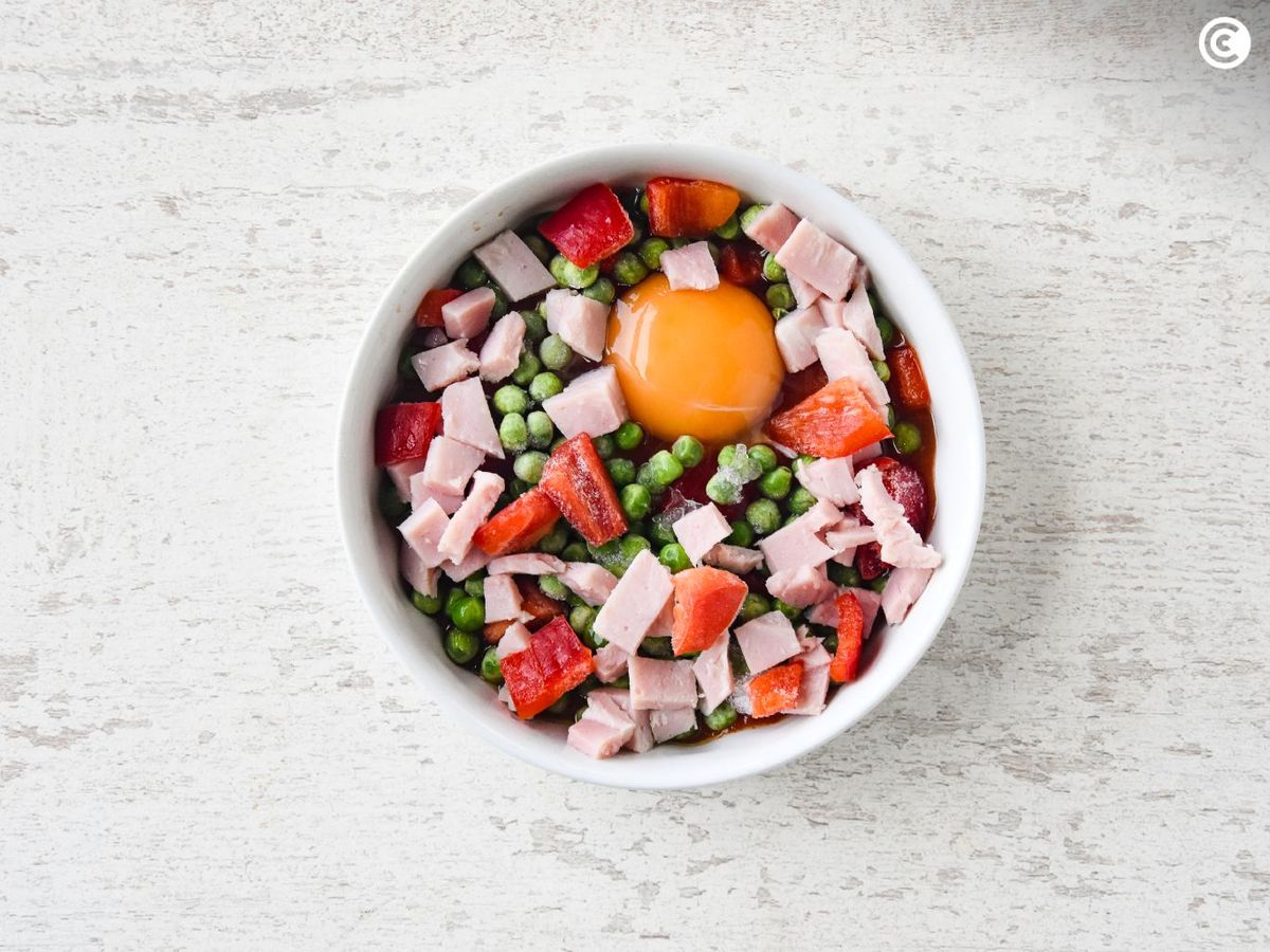 Agregar las verduras y el jamón a los huevos al plato en freidora de aire