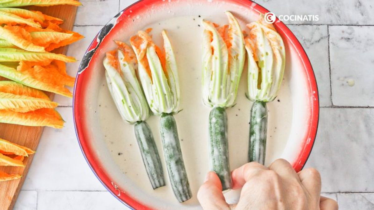 Sumergimos las flores de calabacín en el rebozado