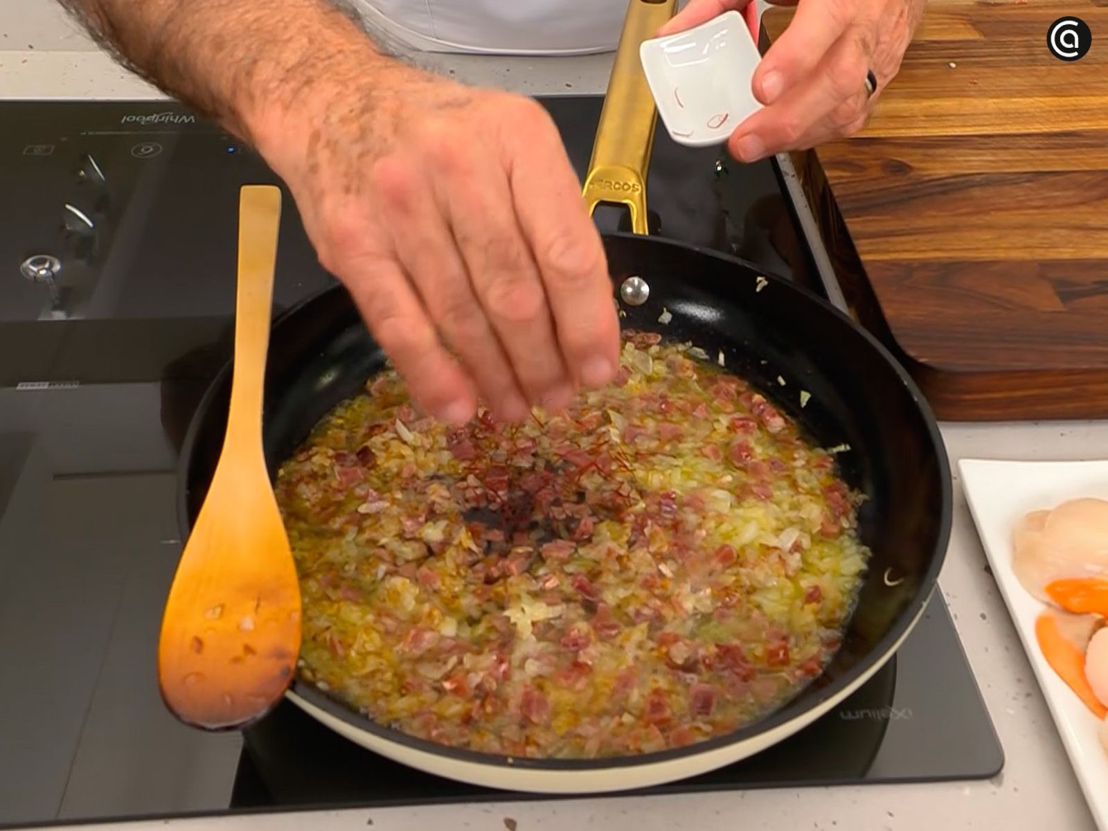 Sofríe las cebolletas con el jamón, incorpora el vino y unas hebras de azafrán