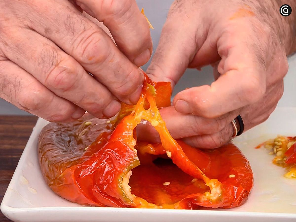 Pela los pimientos asados con los que harás la salsa del bacalao