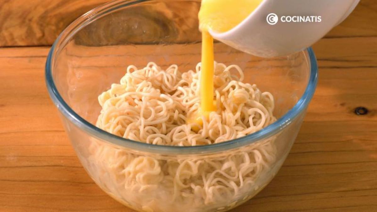 Bate dos huevos y échalos sobre los fideos