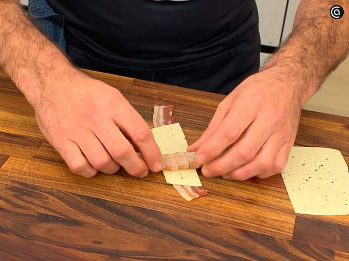 Rodea cada langostino con queso y bacon, formando un rollito