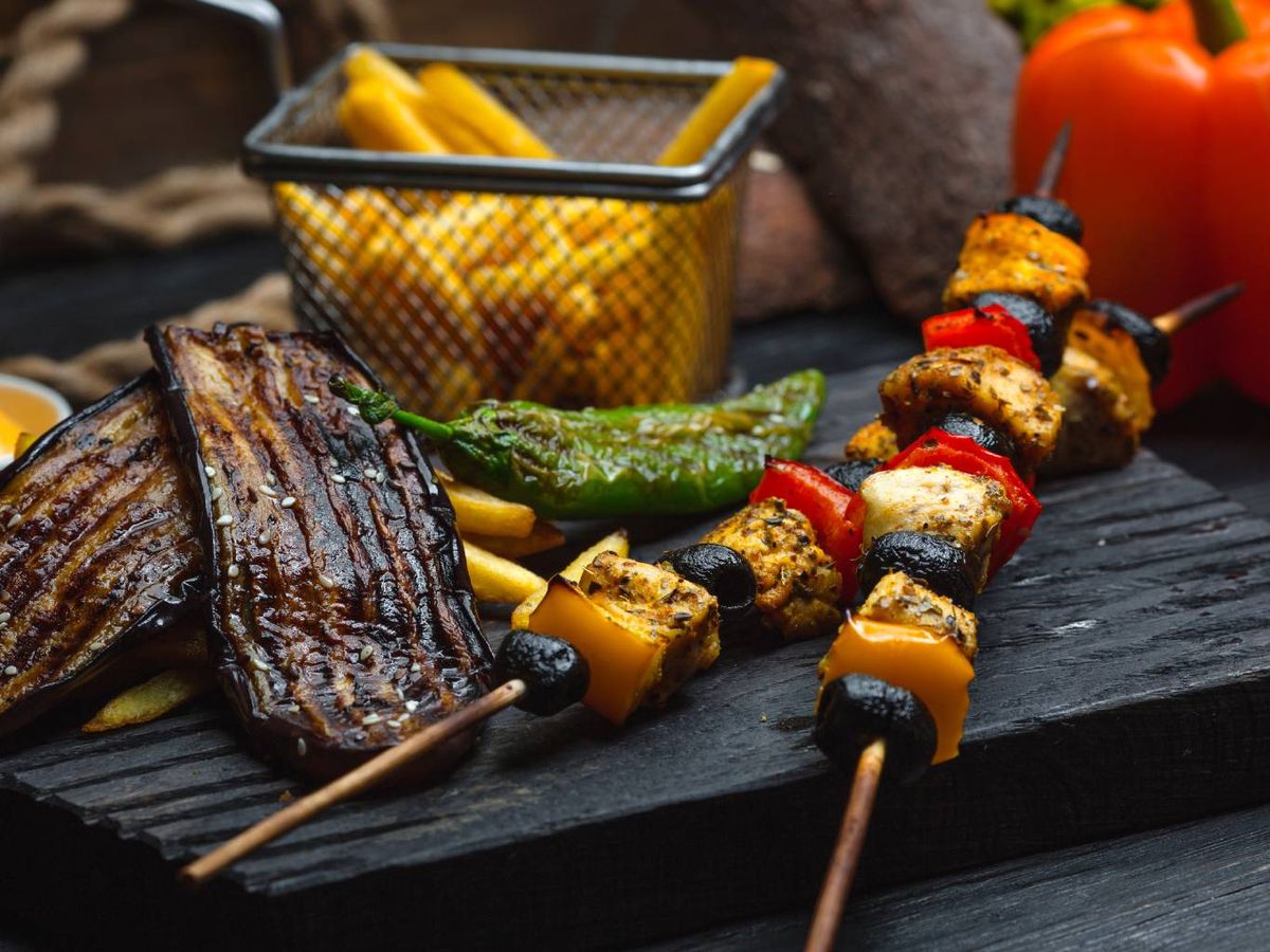 Una parrillada bien pensada: brochetas de pollo, berenjena a la brasa y patatas.