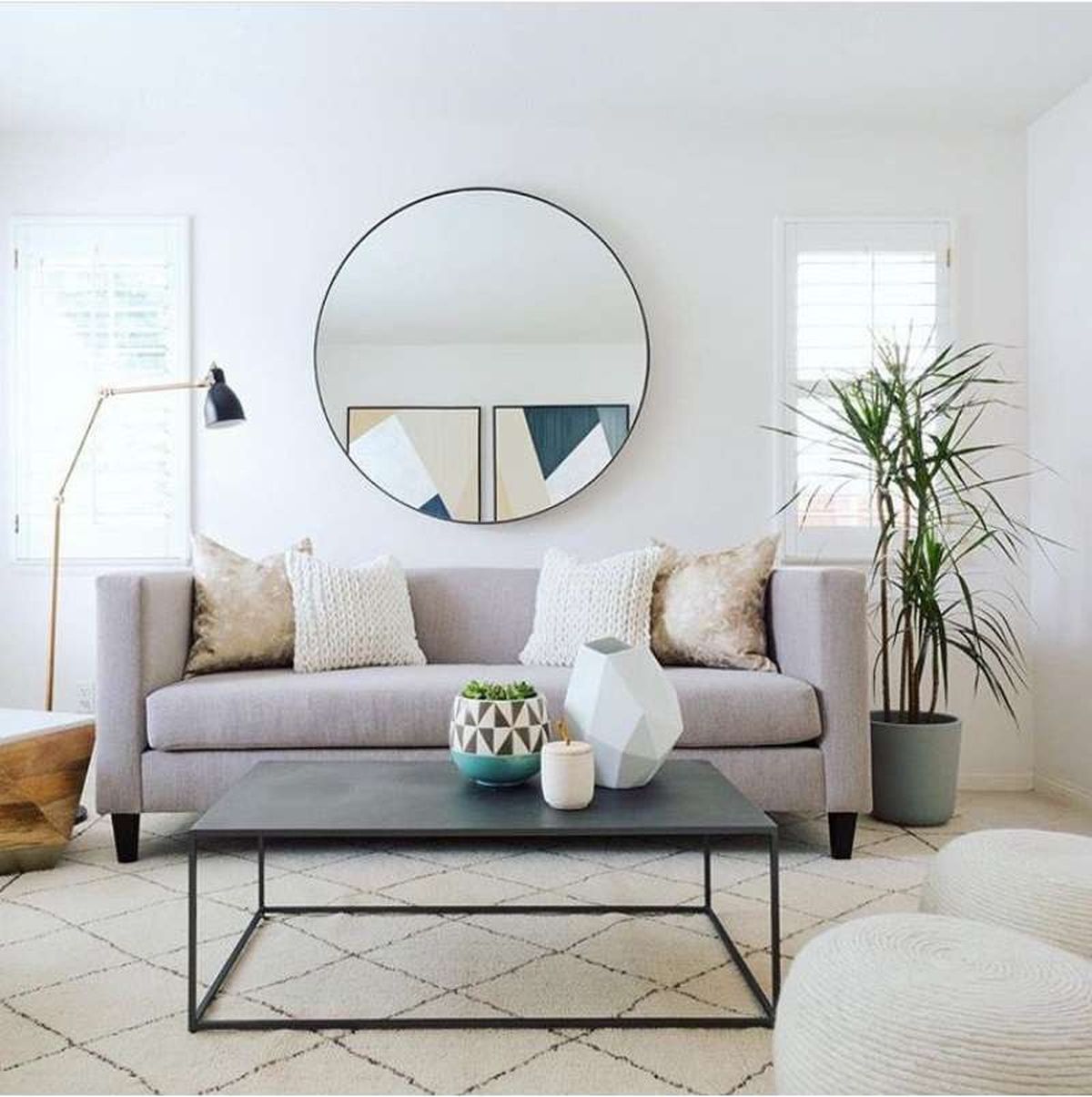 Salón con espejo redondo encima del sofá para atraer la buena energía.