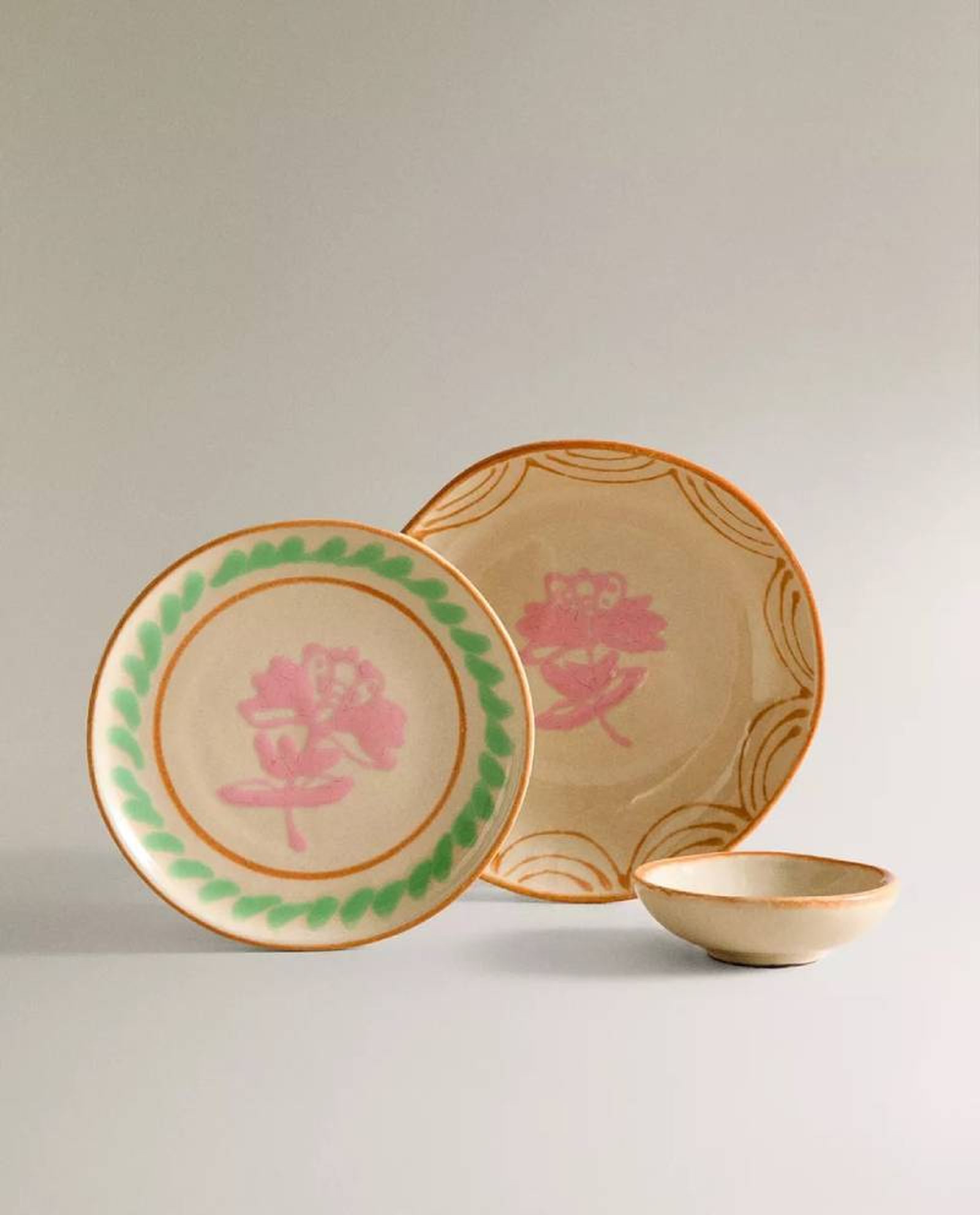 Vajilla beige, rosa y verde Nanushka.