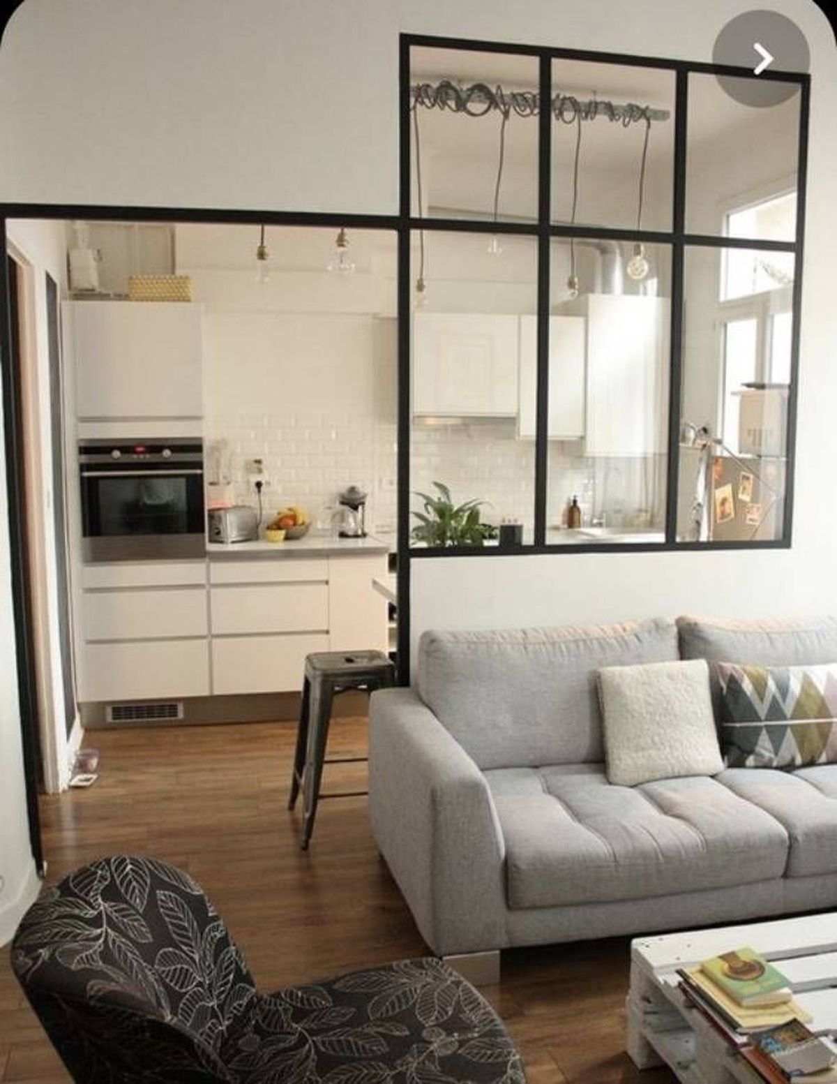 Cocina semiabierta al salón con sofá gris claro.