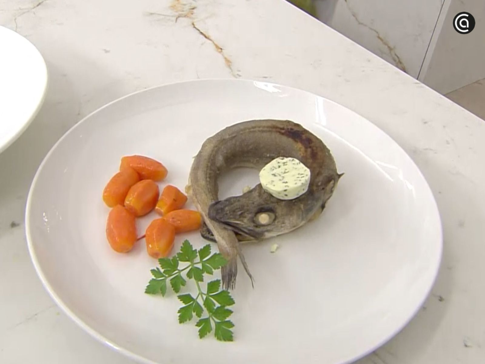 Una rodaja de mantequilla fría se coloca sobre el pescado recién hecho para que se funda lentamente.