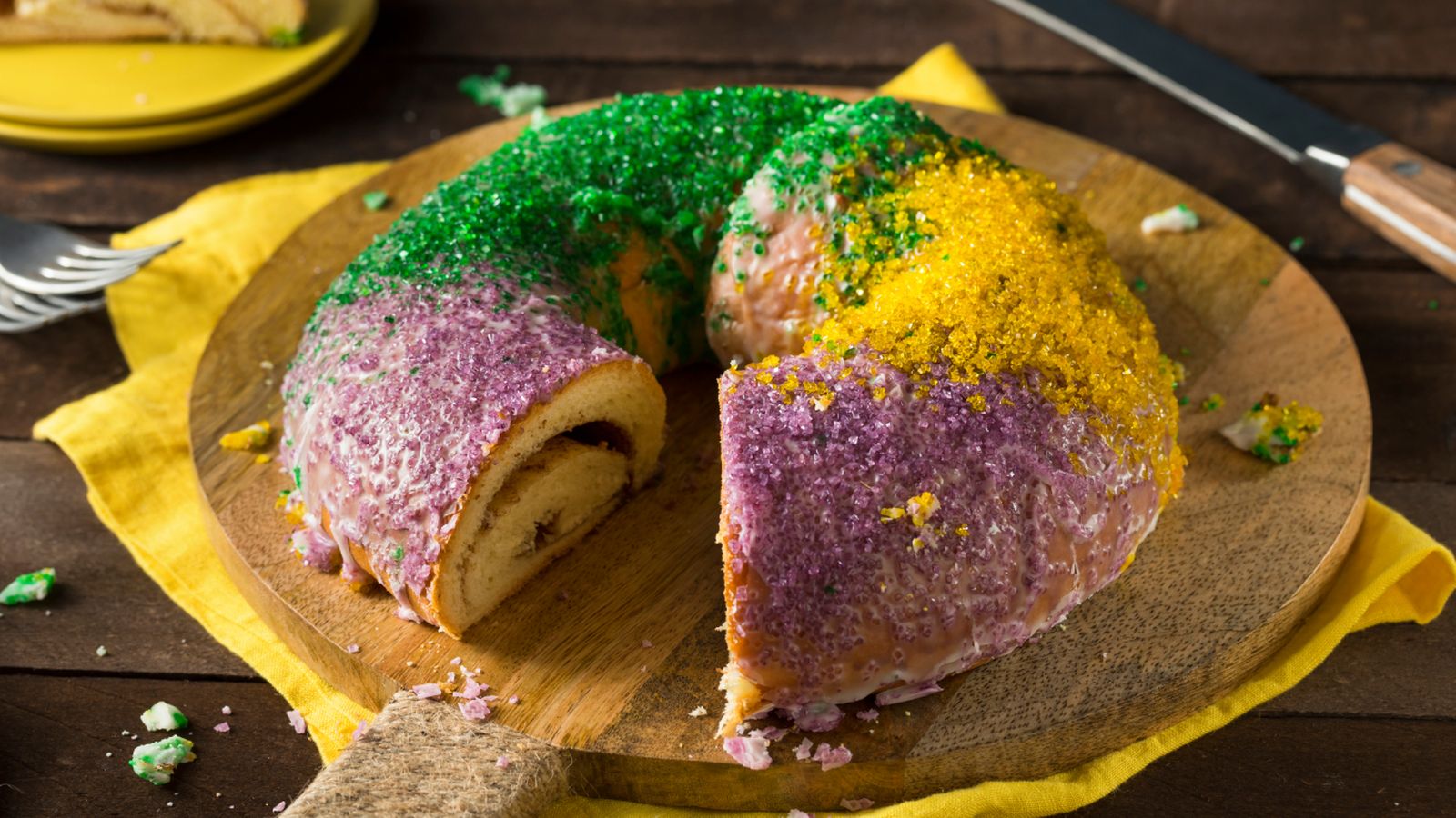 King Cake decorado con los colores del Carnaval de Nueva Orleans: morado, verde y dorado.