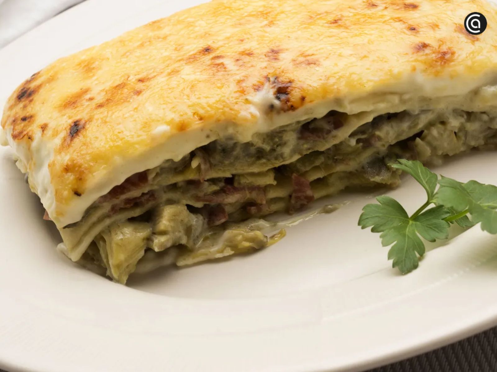 Elegante y sabrosa, esta lasaña combina alcachofas salteadas con jamón ibérico y bechamel para un plato lleno de matices.