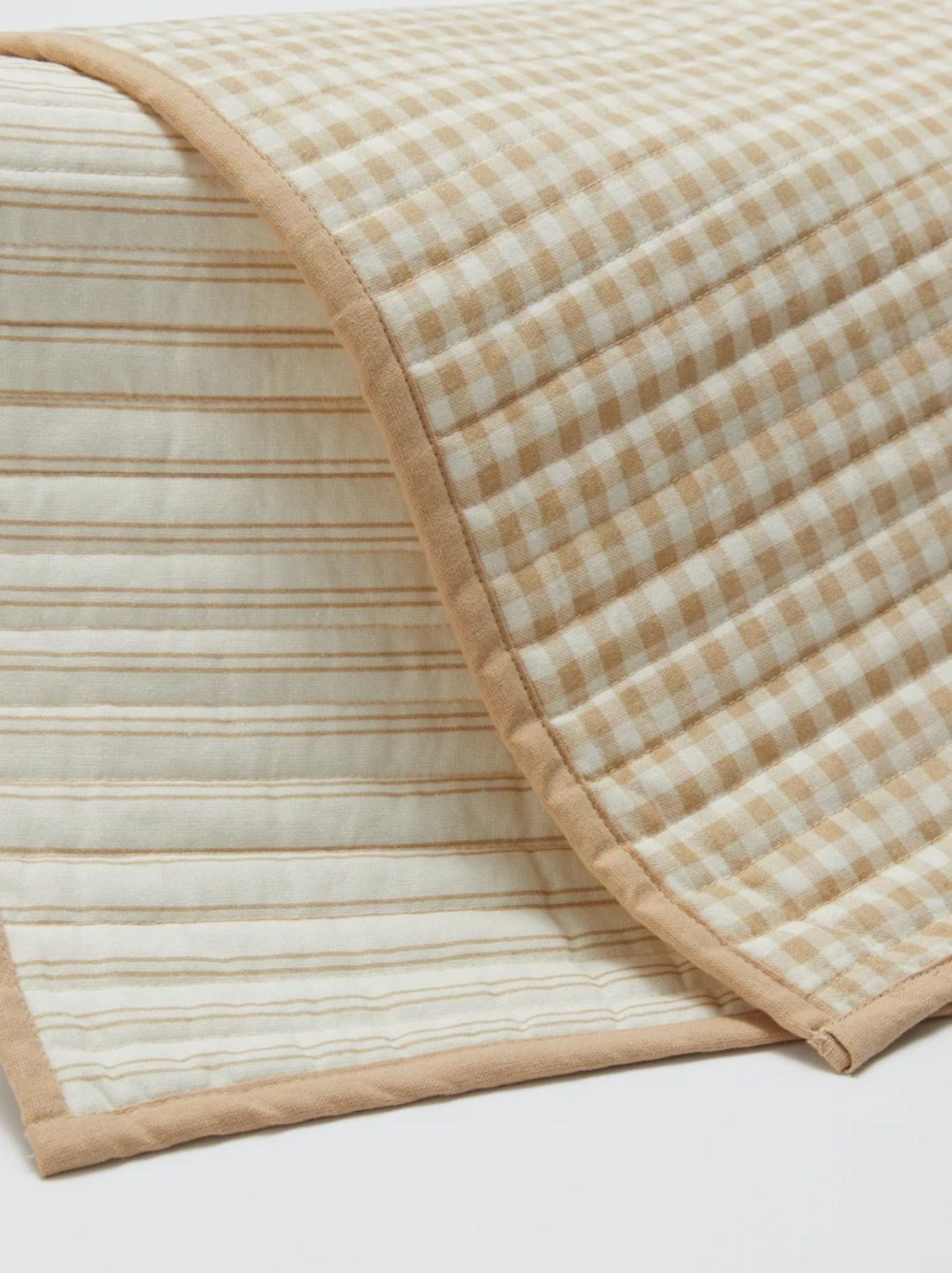 Mantel individual reversible de cuadros beige.