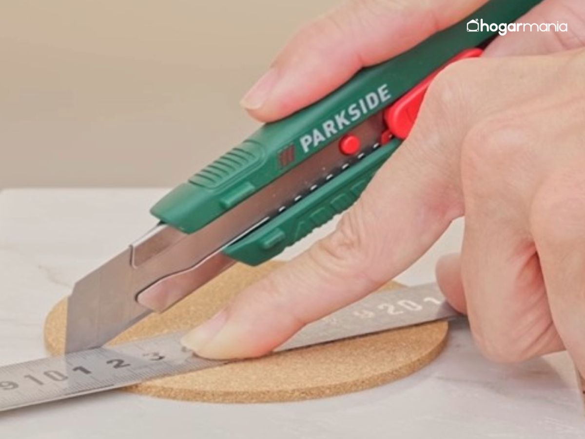 Con un cúter, se cortan los discos de corcho siguiendo la marca para obtener medias lunas y fragmentos curvos.