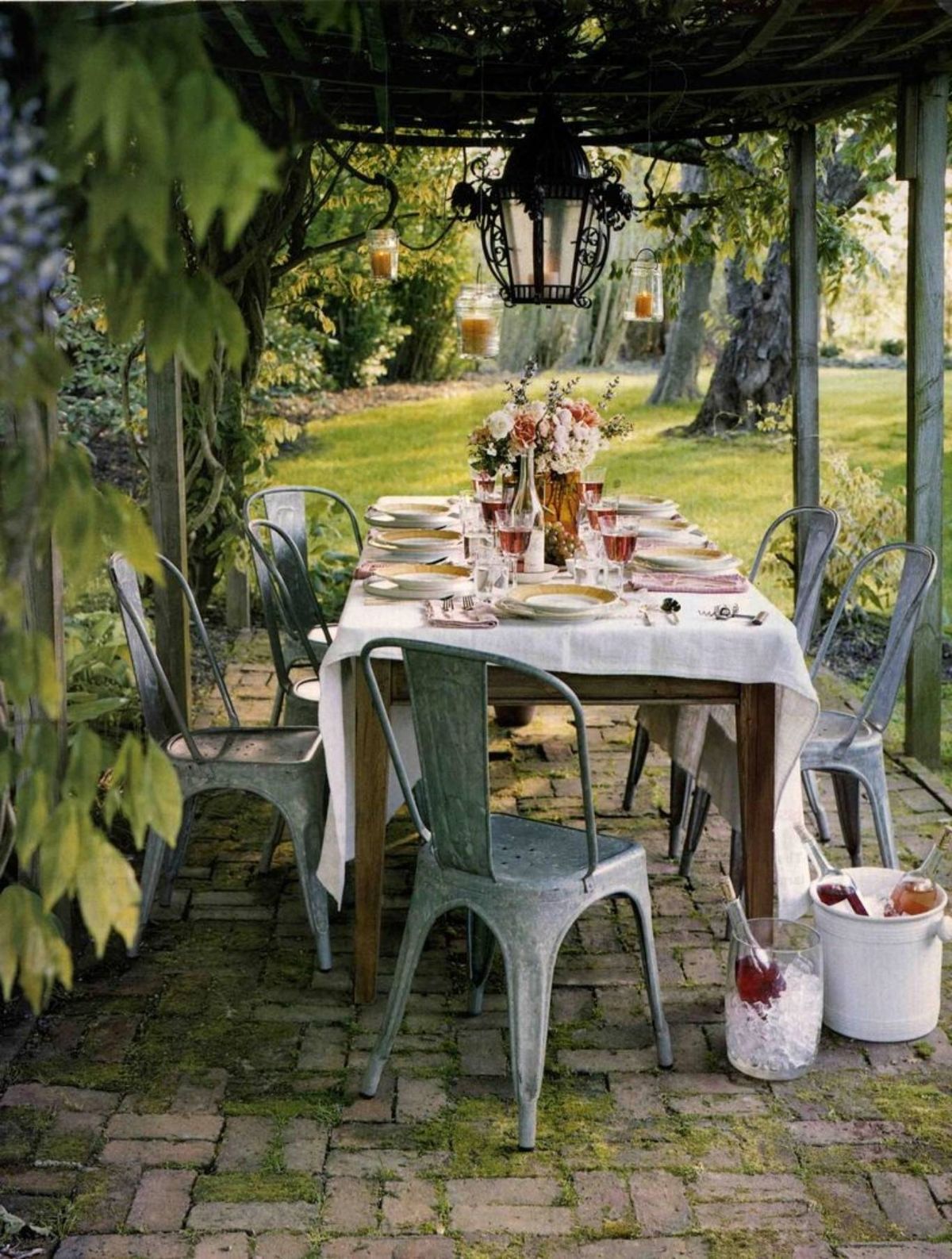 Mesa de madera con sillas Tolix y mantel bordado floral