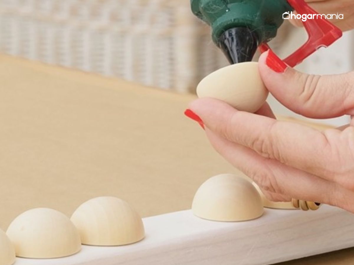 Se aplica un poco de silicona caliente en cada media esfera y se van pegando una a una, bien centradas, hasta cubrir todo el perímetro.