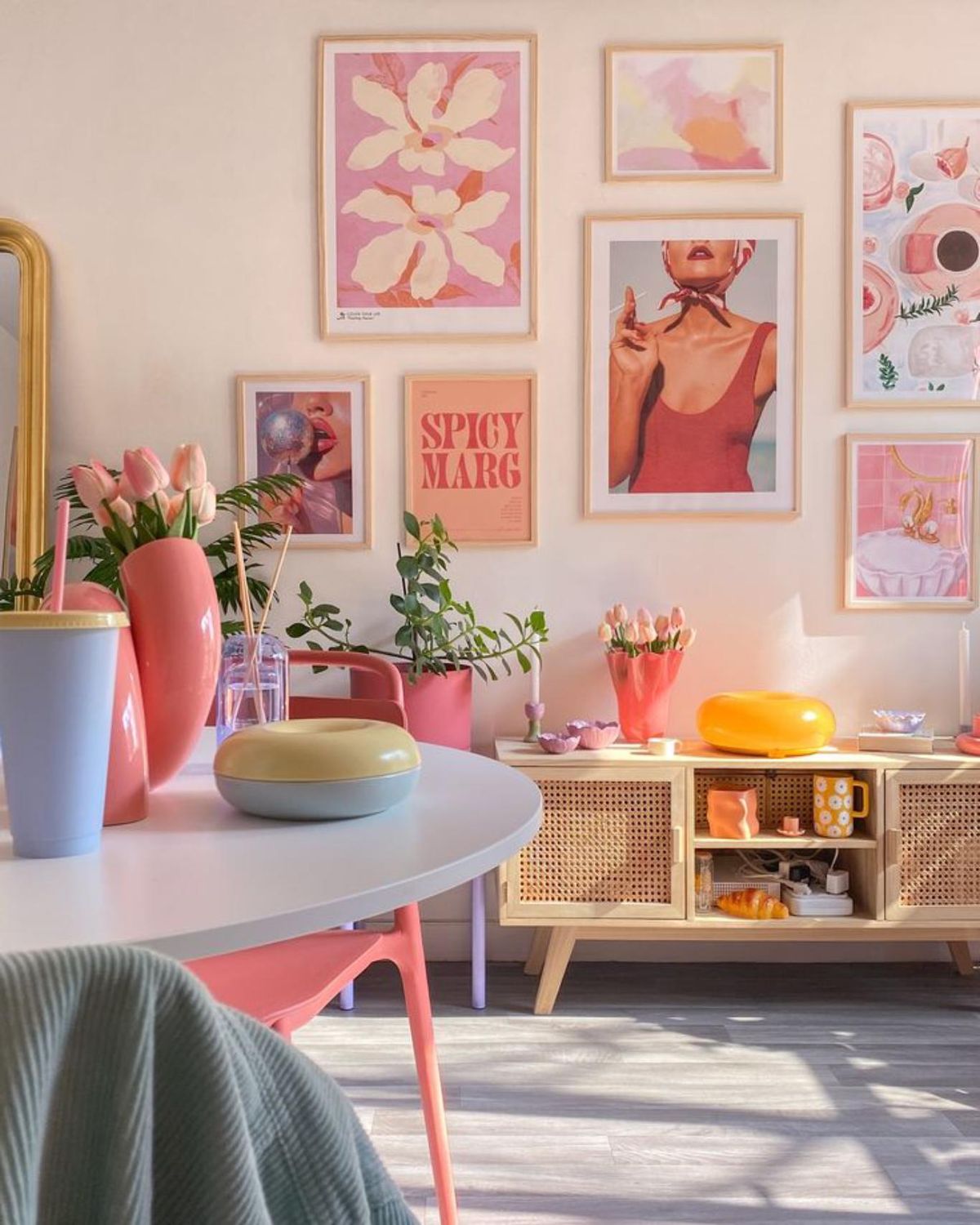 Rincón del salón con la pared decorada con cuadros coloridos.